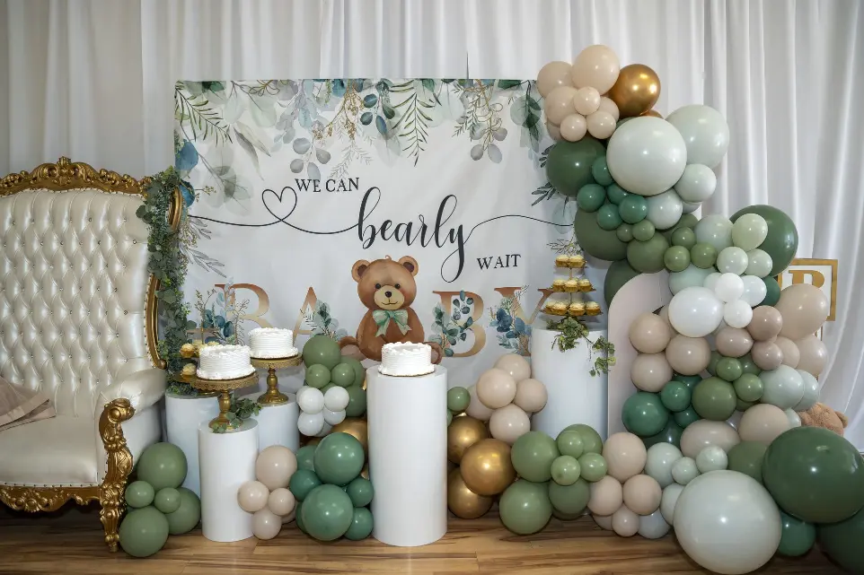 Baby shower setup with green and gold balloon décor and custom backdrop at Unique Touch Events.