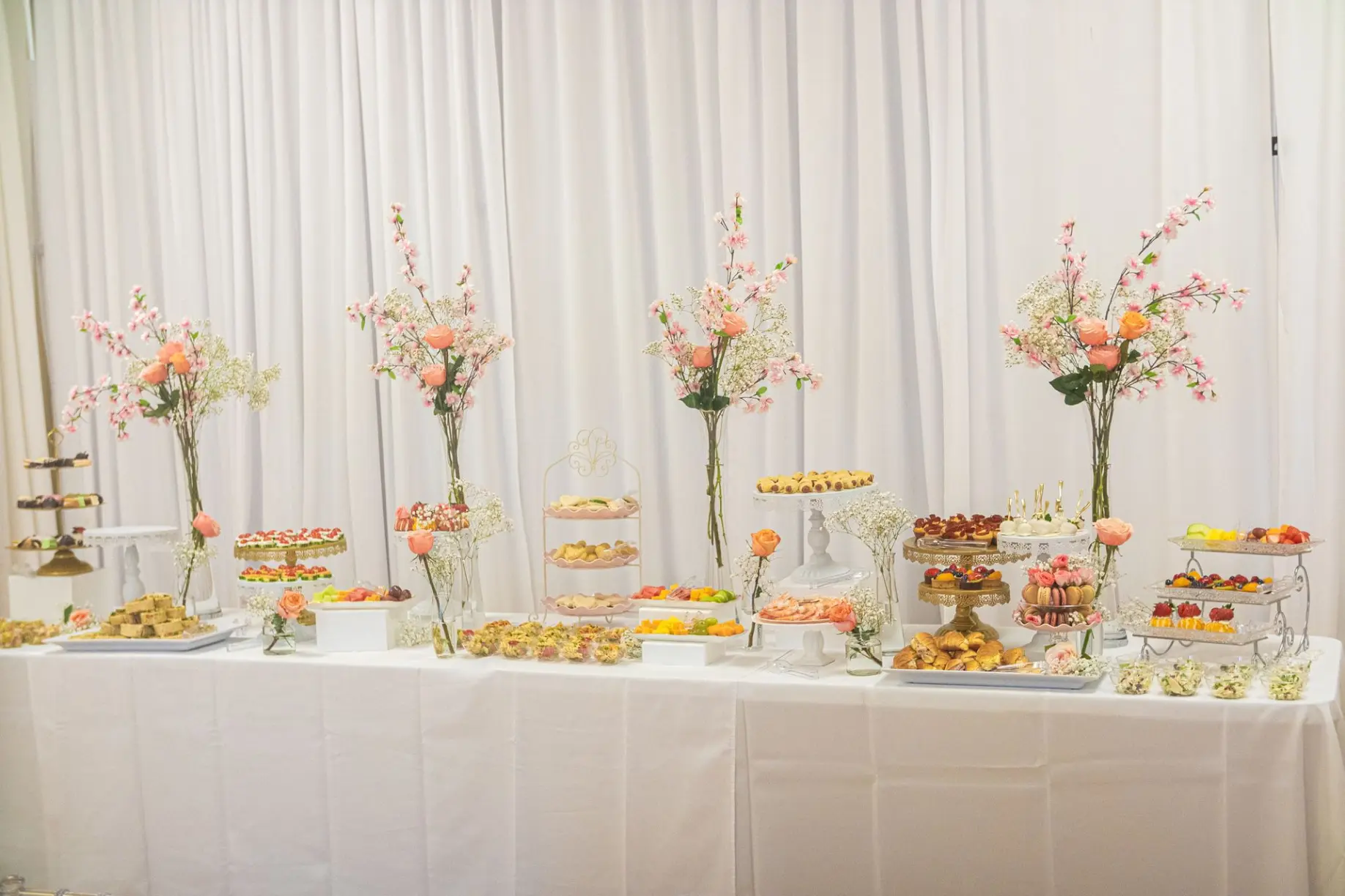 Elegant brunch table with pastel floral arrangements and gold details.