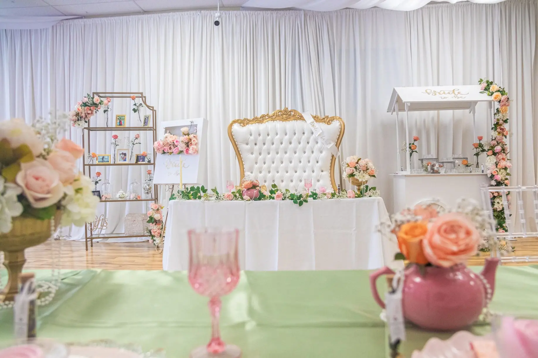 Elegant brunch table with pastel floral arrangements and gold details.