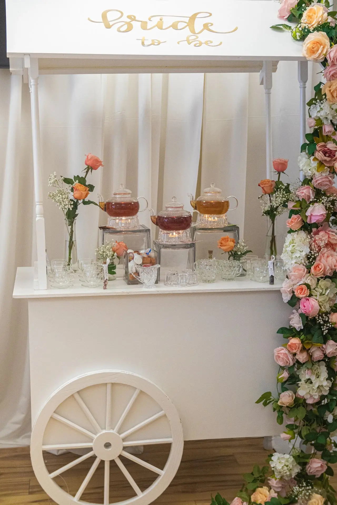Elegant brunch table with pastel floral arrangements and tea cart display 